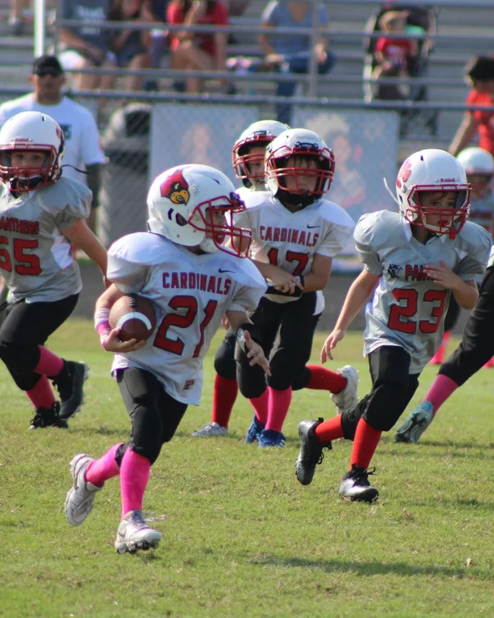 Young Four Oaks Rookie players running with the ball on game day