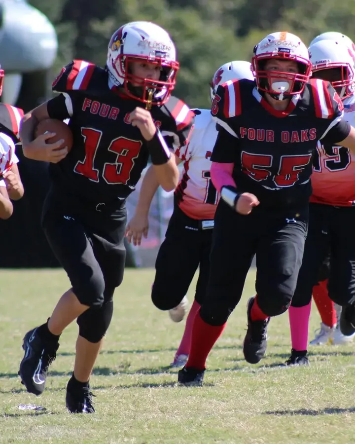 Four Oaks varsity players running onto the field
