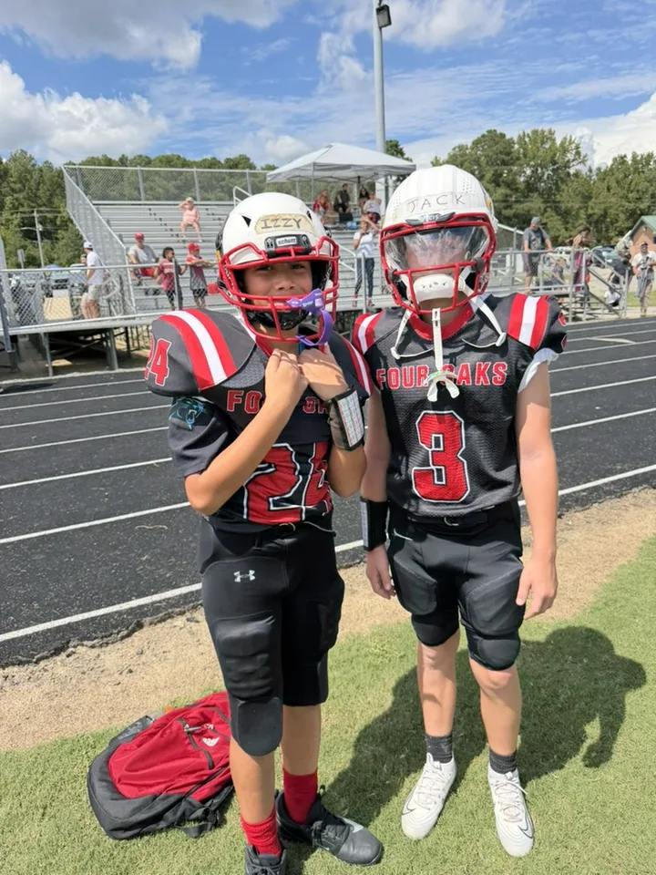 Two young Four Oaks players standing side by side in black jerseys
