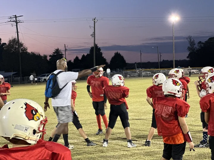 Four Oaks coaches and players on the sideline