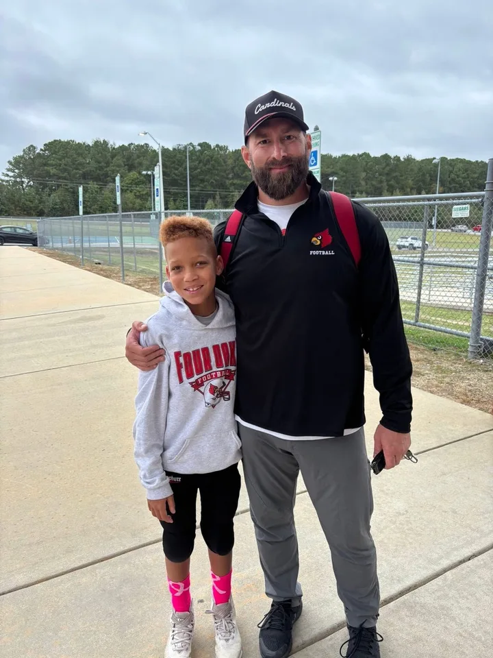 A Four Oaks coach with a young Four Oaks player