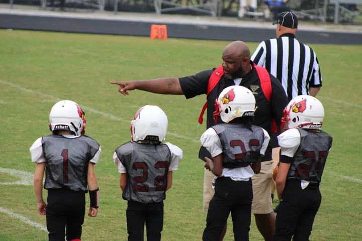A Four Oaks coach pointing out the next play to young players