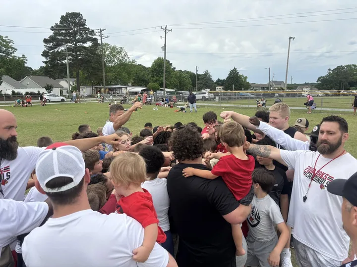 Four Oaks coaches and players huddled up at practice