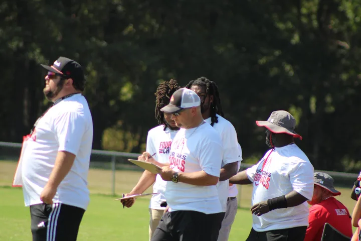Four Oaks coaches talking on the sideline