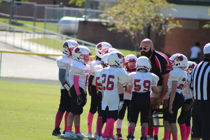 A Four Oaks coach with young players on game day