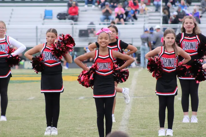 Four Oaks Cardinals cheer squad performing on the sideline
