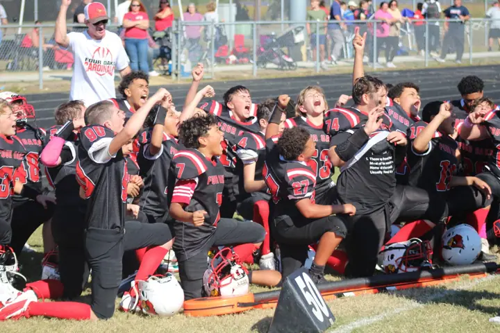 Four Oaks players celebrating on the sideline