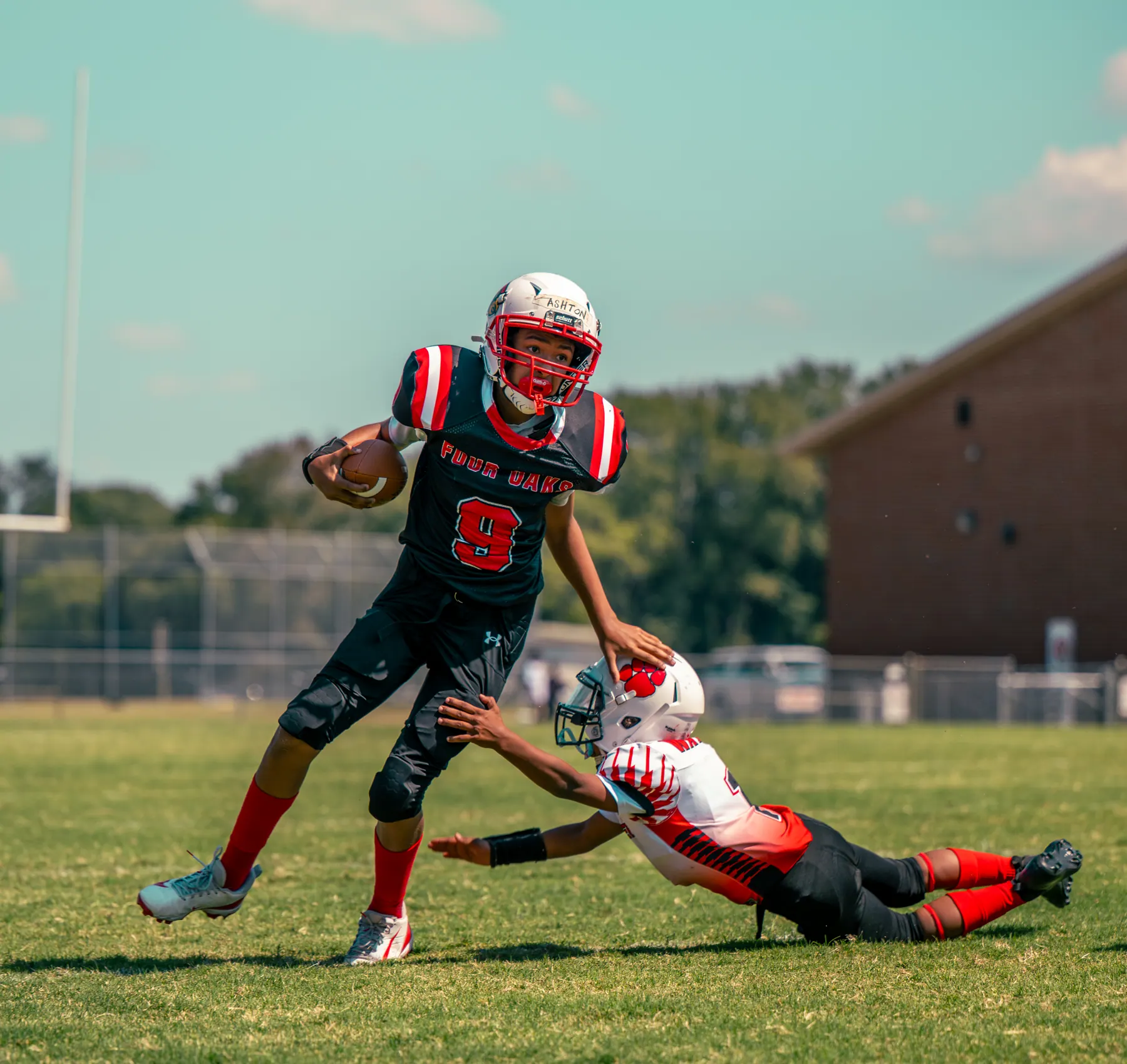 Four Oaks player breaking a tackle with the ball