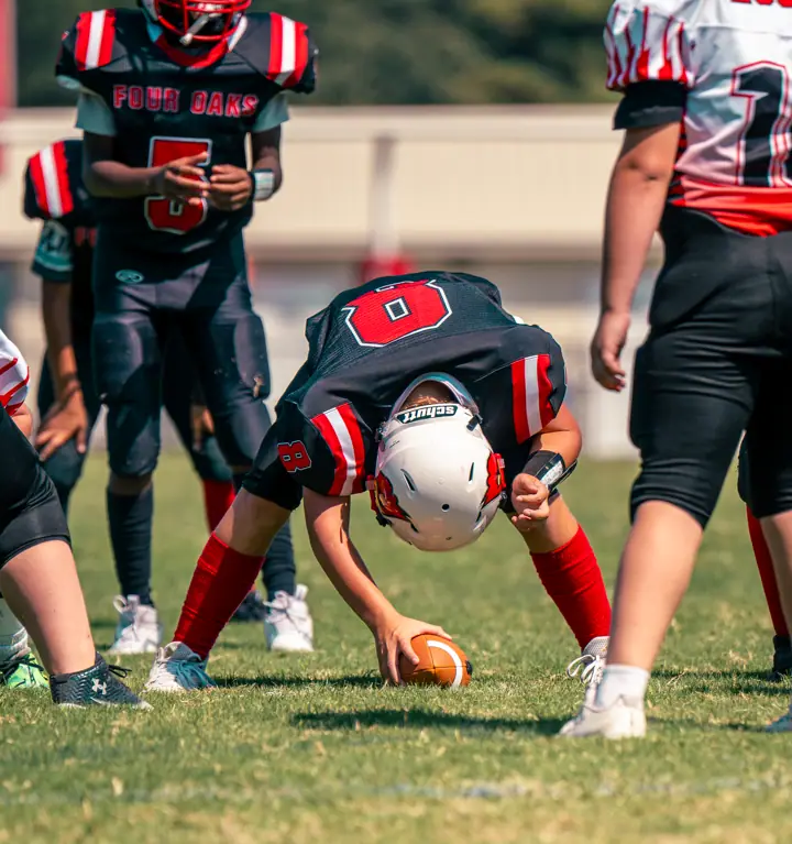 Four Oaks center snapping the ball to the quarterback